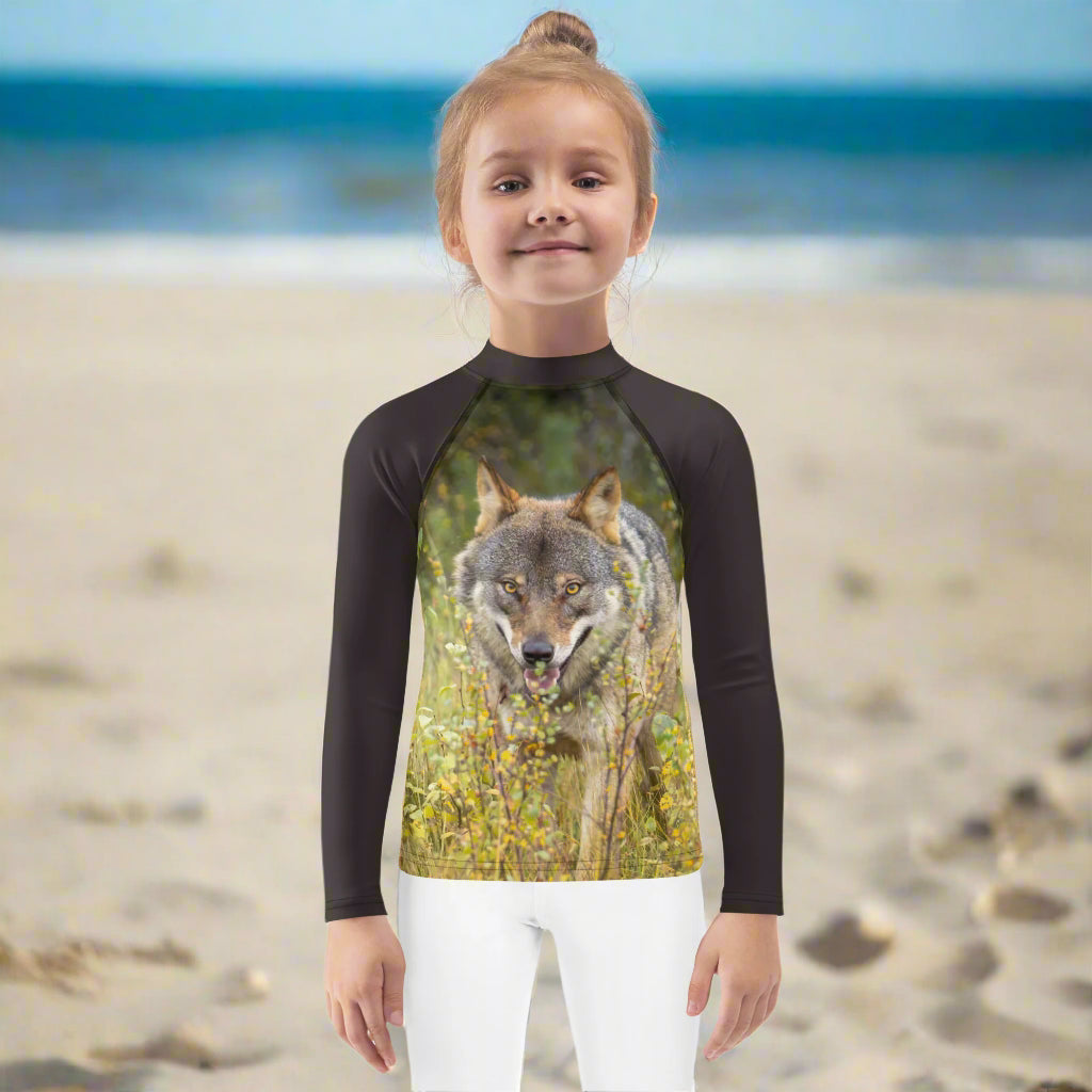 A girl wearing a rashguard with an image of a wolf looking straight at you. Photo and design by Rosenmay Studio