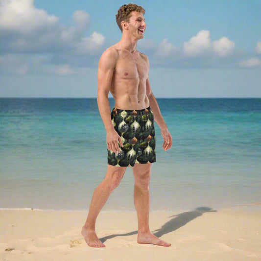 Man wearing swimtrunks from Rosenmay Studio. The pattern is forest green and dune sandy